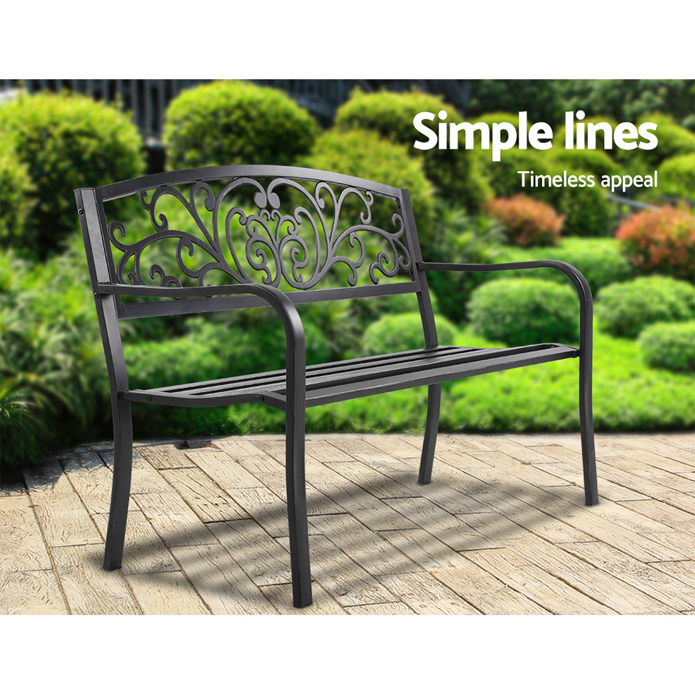 Black steel outdoor garden bench with decorative scroll back and slatted seat