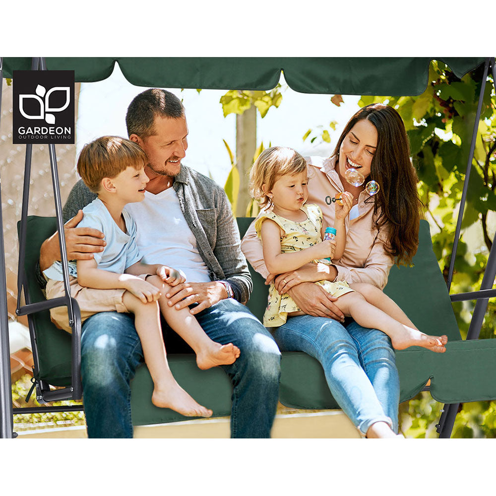 Green 3-seat outdoor swing bench with canopy, with family seated on cushions
