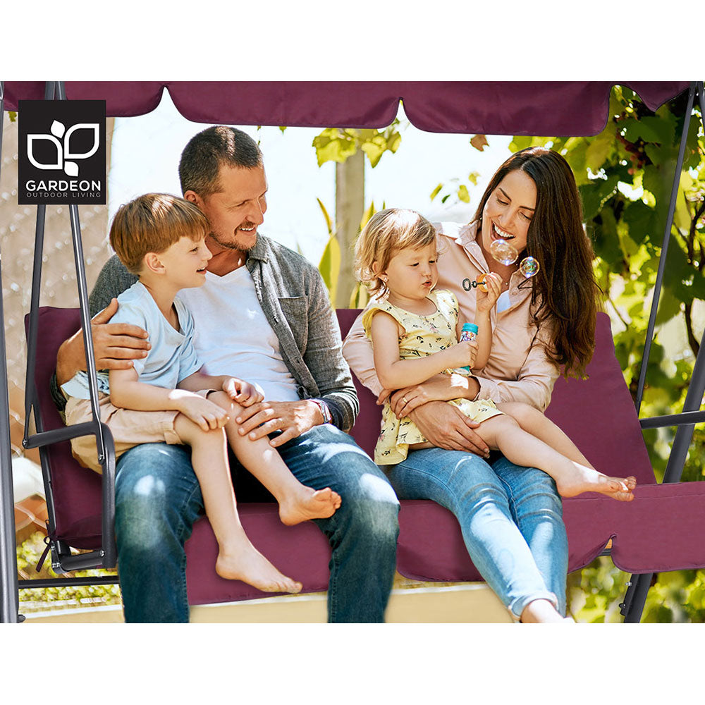 Wine red outdoor swing chair with canopy, family seated on the padded cushions