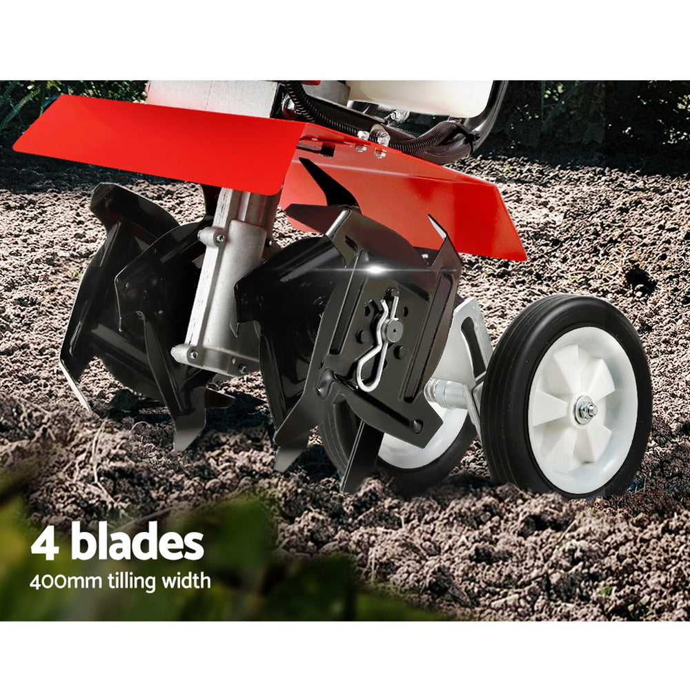 Red tiller with metal blades in soil and front transport wheel