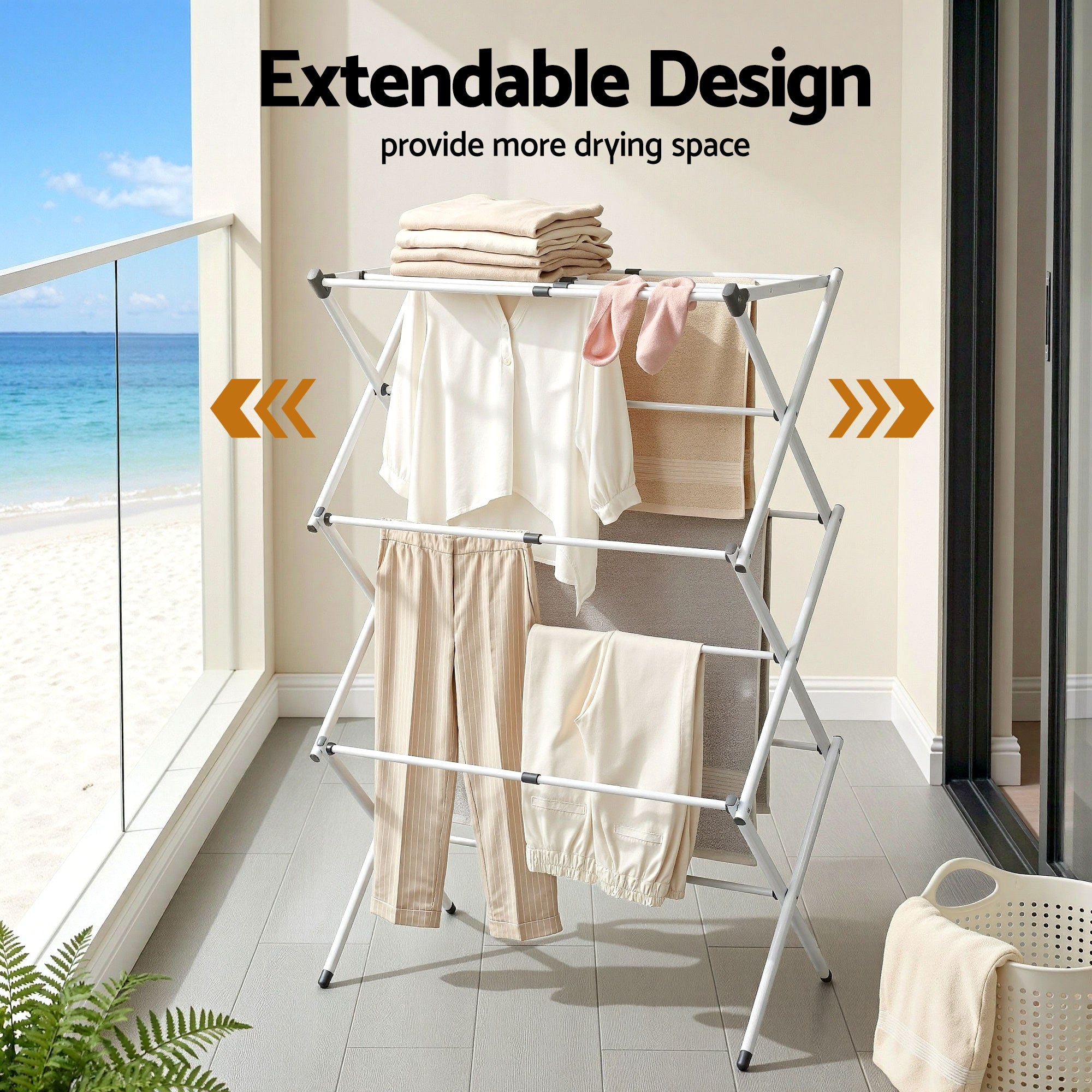 White expandable clothes drying rack holding several towels and shirts