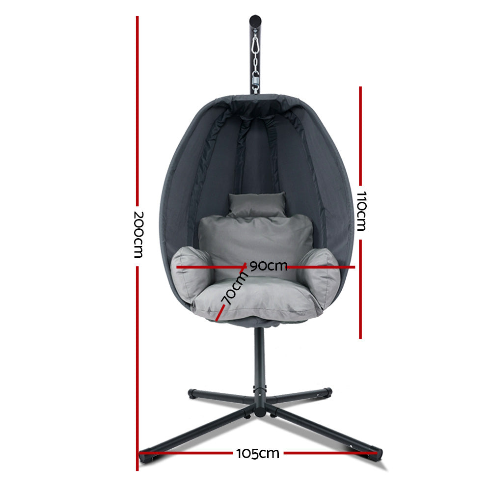 Hanging egg pod chair with black canopy and light gray seat cushions, on cross-leg base