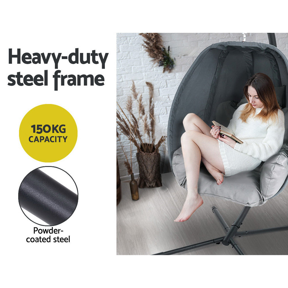 Egg swing chair with dark gray steel frame and black canopy, light gray seat cushion