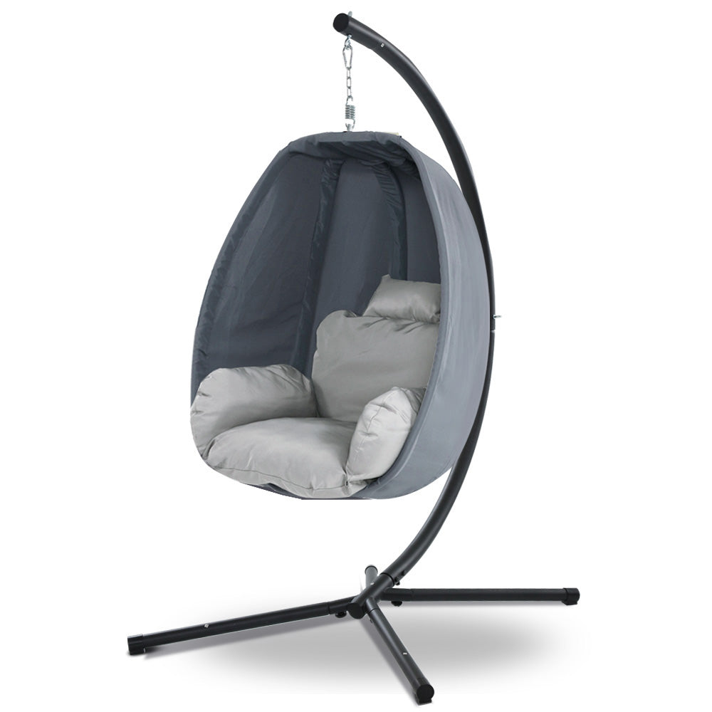 Egg swing chair with black canopy, light gray cushions, and dark gray curved stand legs