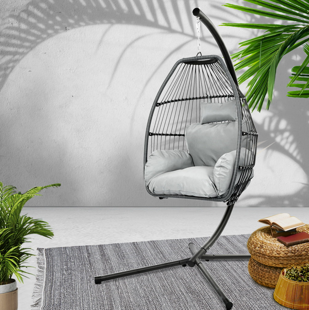 Hanging egg swing chair with black frame and grey cushions, curved stand