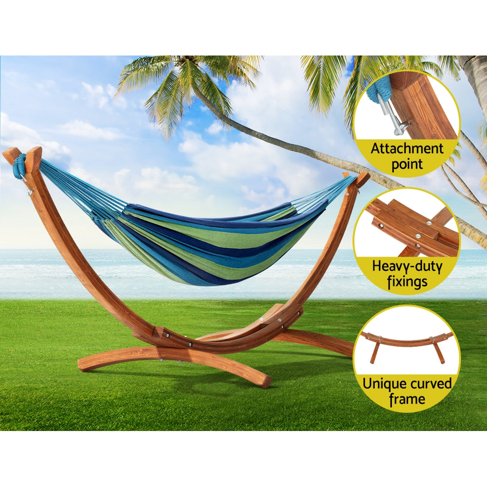 Outdoor hammock on a curved wooden stand with blue and green striped fabric