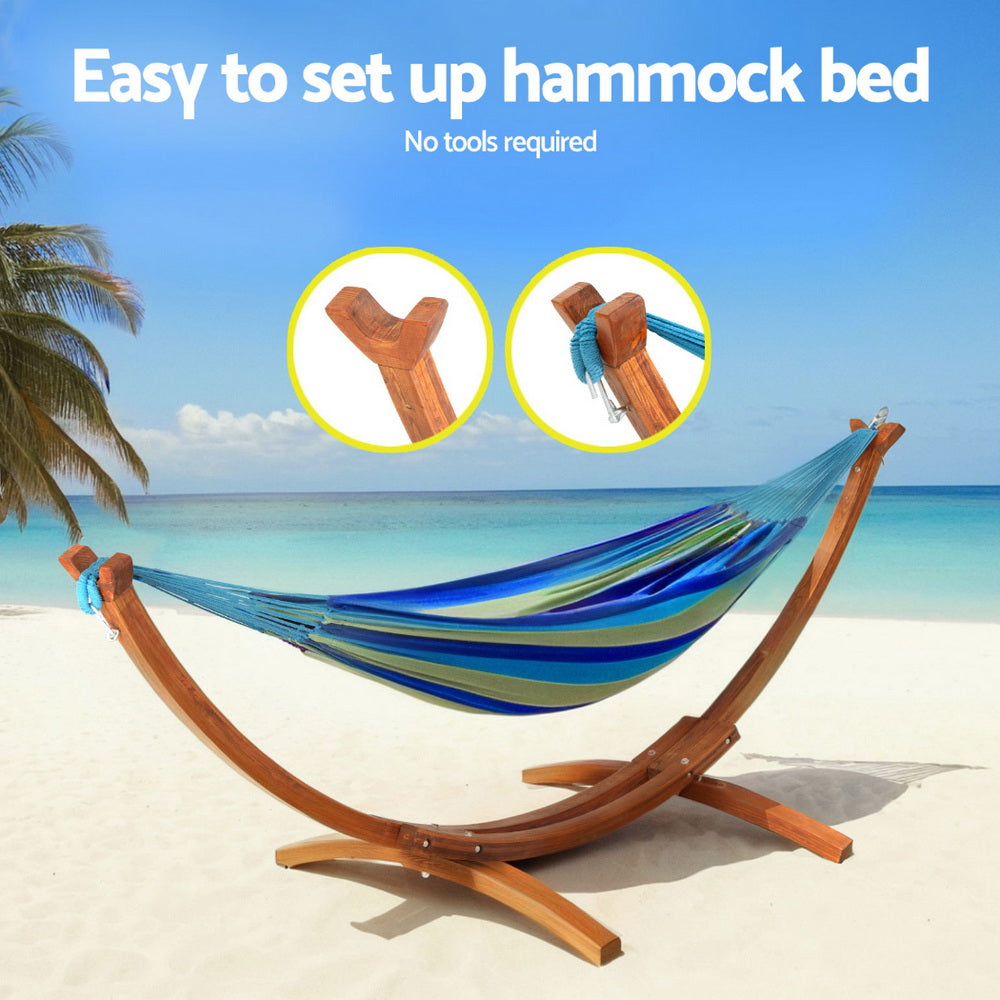 Larch wood hammock bed stand holding a blue-and-white striped hammock