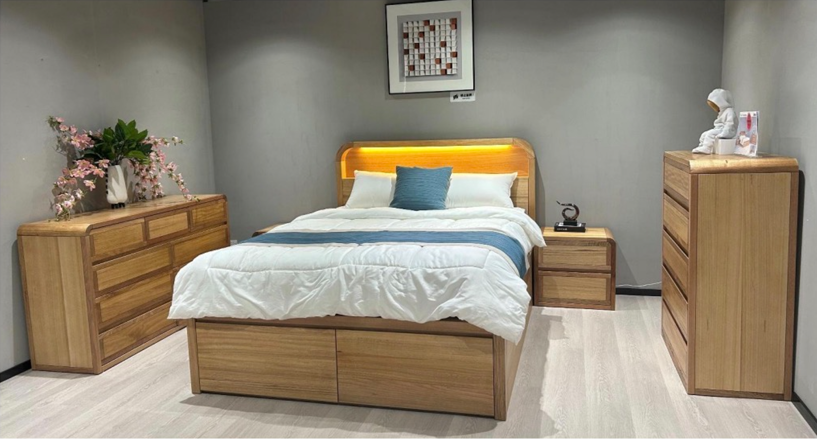 Wooden bedroom furniture set with bed, dressers, and nightstands in a room.