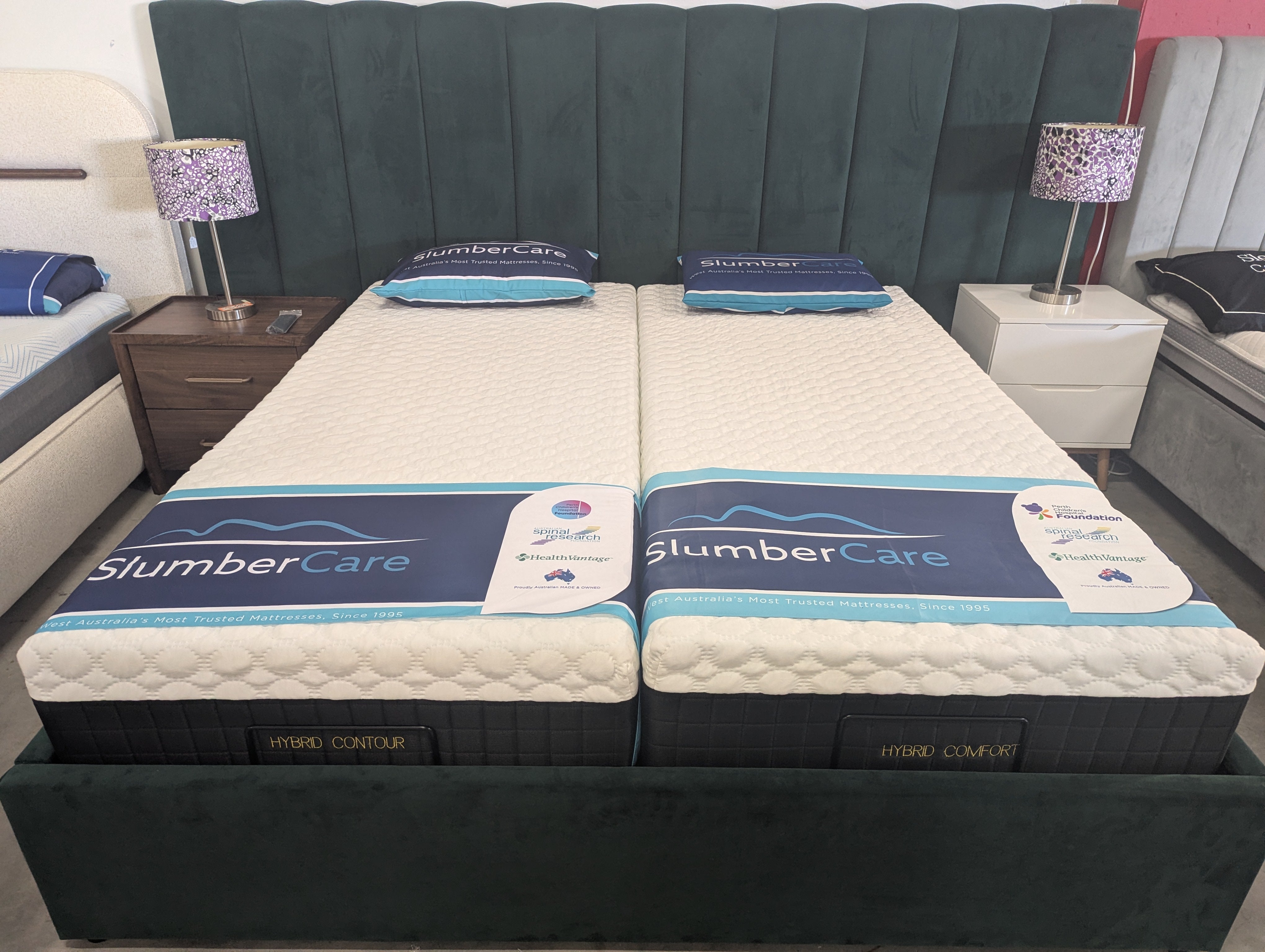 Hybrid contour mattresses set on bed base, white quilted tops with blue trim and labels.