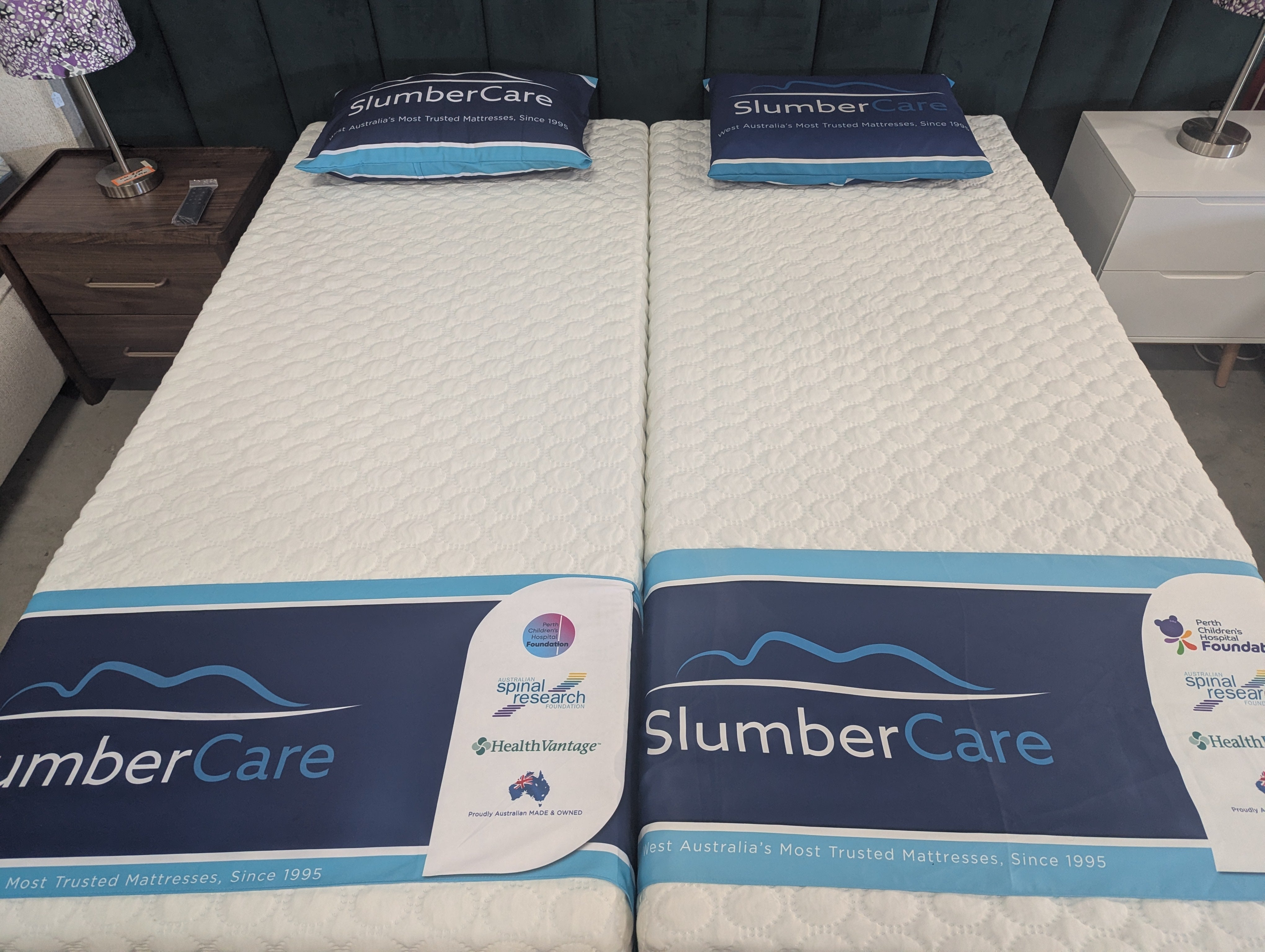 Hybrid contour mattresses with white quilted tops and blue edge labels on a dark base.
