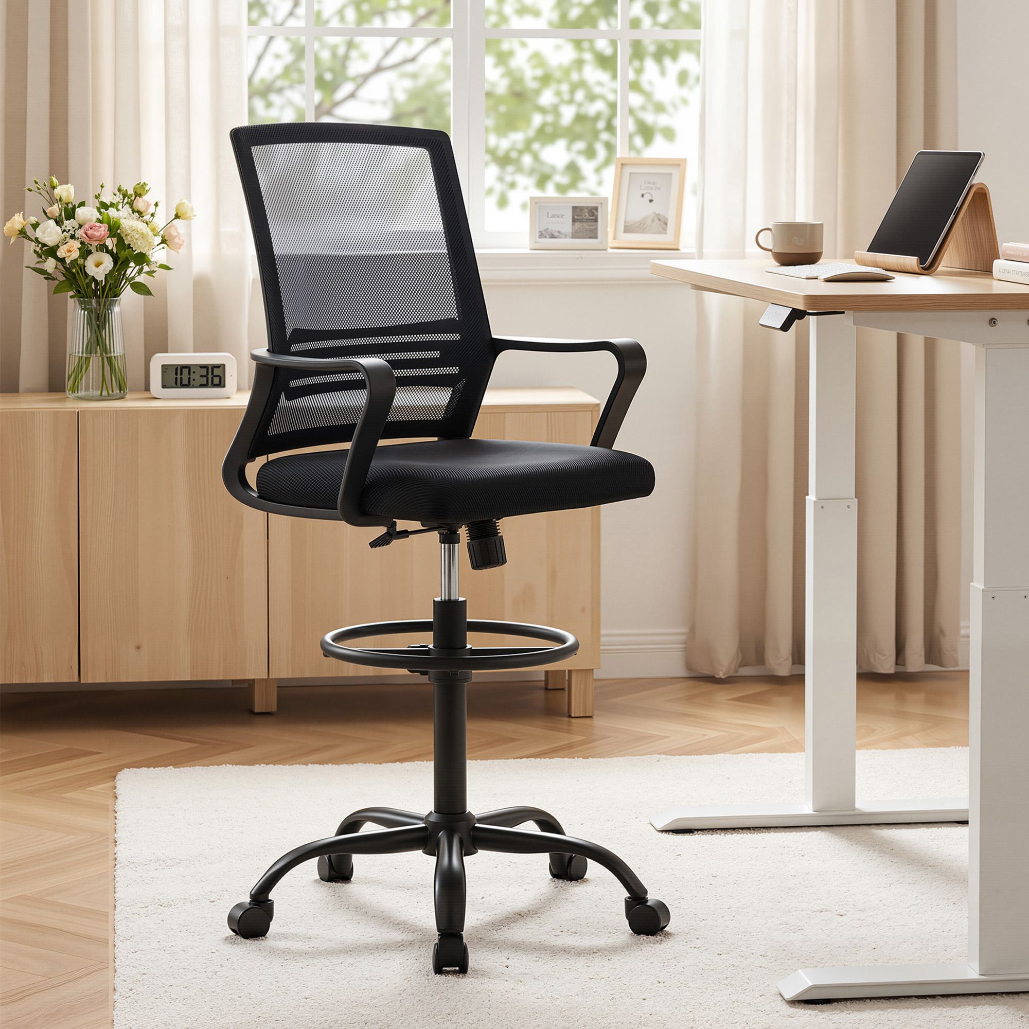 Black mesh-backed drafting chair with padded seat, swivel base, and casters
