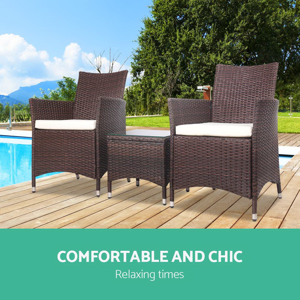 Two dark brown wicker patio chairs with white cushions