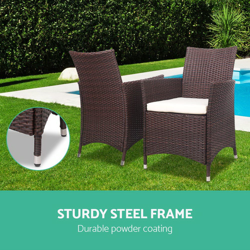 Two dark brown wicker patio chairs with white cushions, showing leg detail