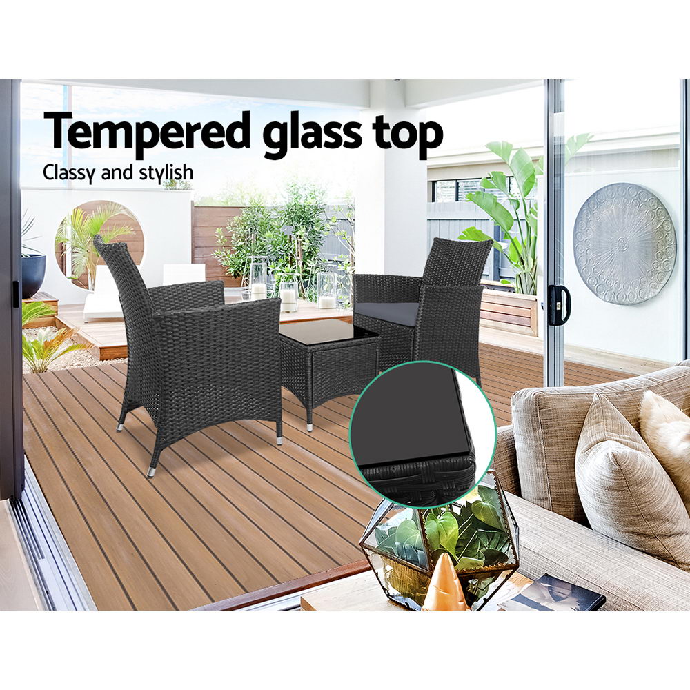 Dark wicker bistro set with tempered glass table top and gray chair cushions