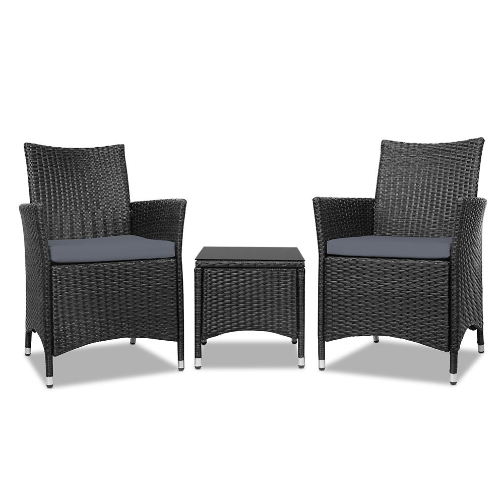 Three dark wicker bistro chairs with gray cushions and a matching square side table