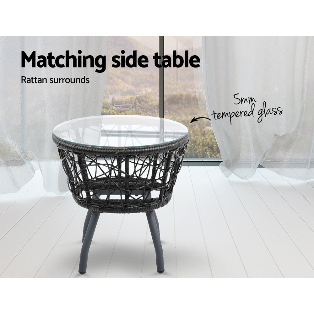 Round side table with clear top and black woven wicker base
