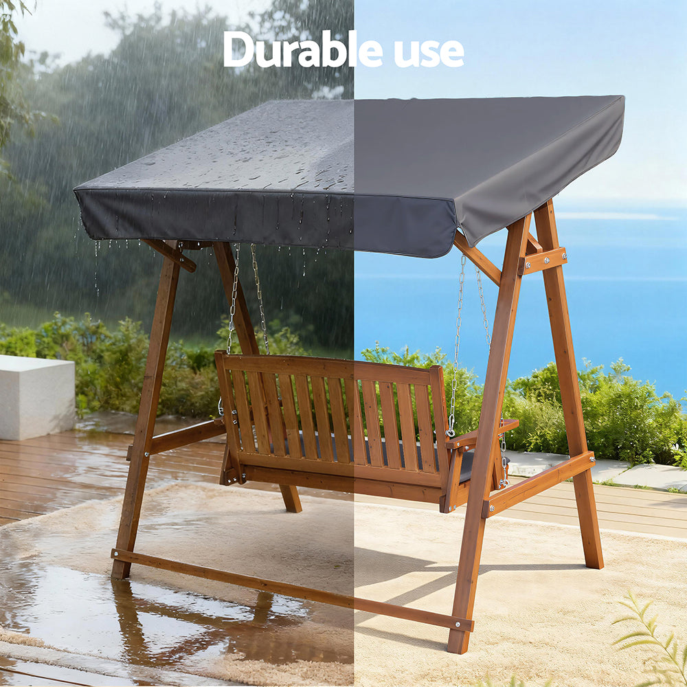 Outdoor wooden swing bench with canopy over dark gray cushions and chain hanging