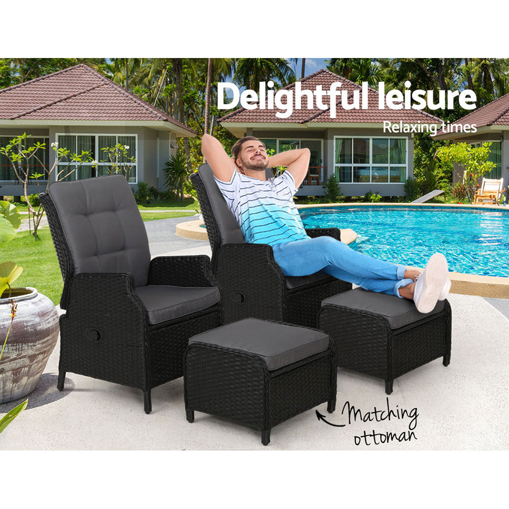 Outdoor wicker recliner chairs with gray cushions and matching ottoman, set for lounging