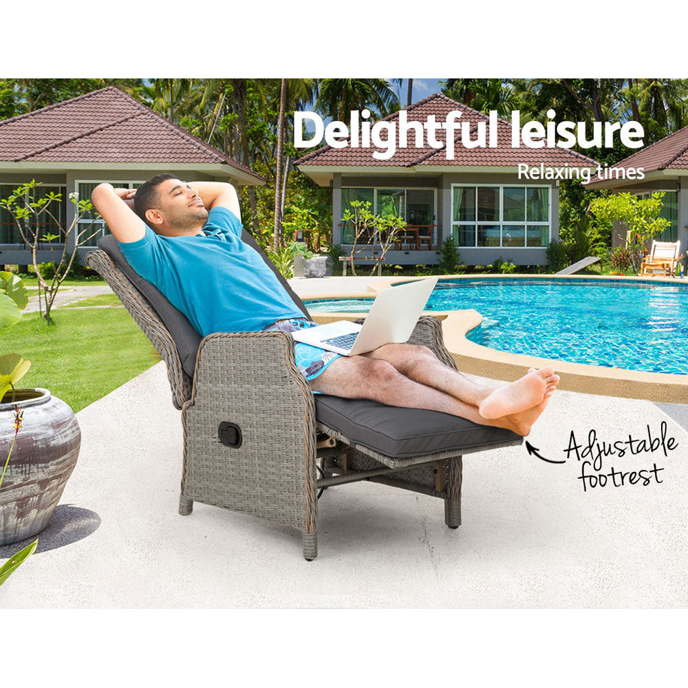 Outdoor recliner chair with grey cushions and extended footrest, woven wicker frame