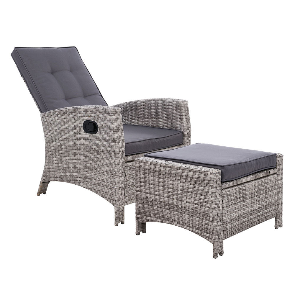 Grey wicker recliner chair with dark grey seat pad, padded backrest, and ottoman