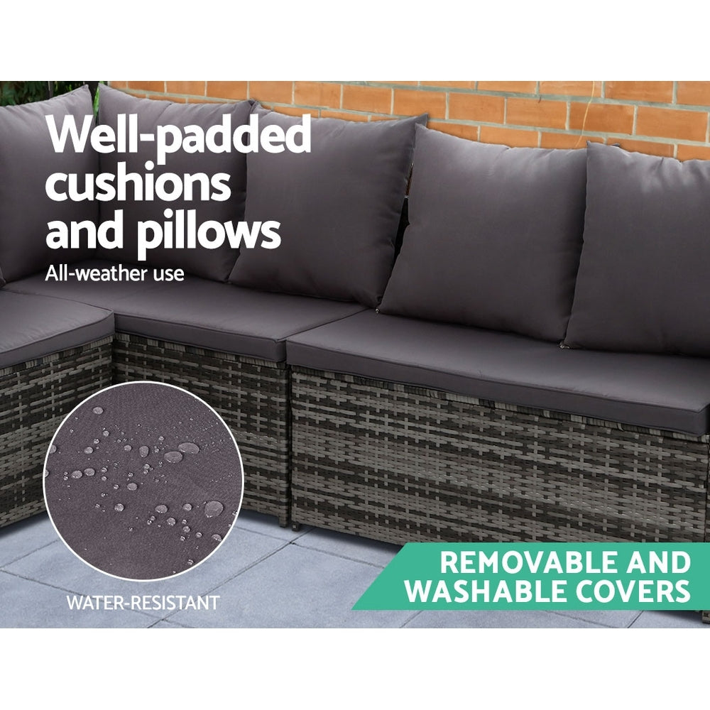 Outdoor wicker corner sofa with padded dark gray cushions and matching pillows