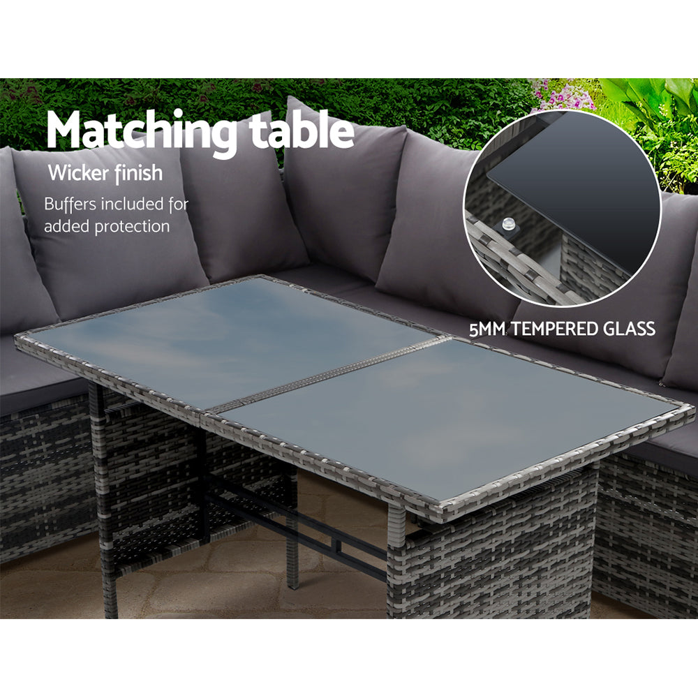 Outdoor square glass-top table with grey cushioned corner sofa seating