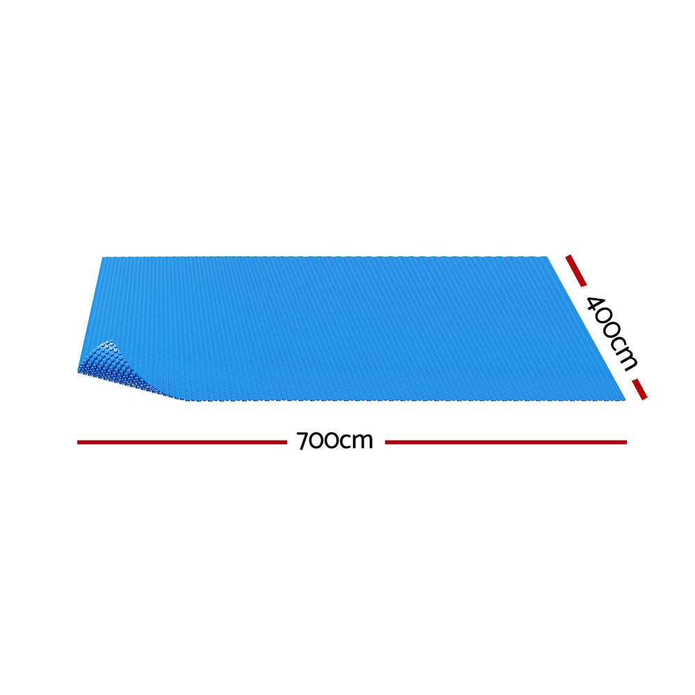Blue solar pool cover blanket, flat sheet with textured bubble surface.