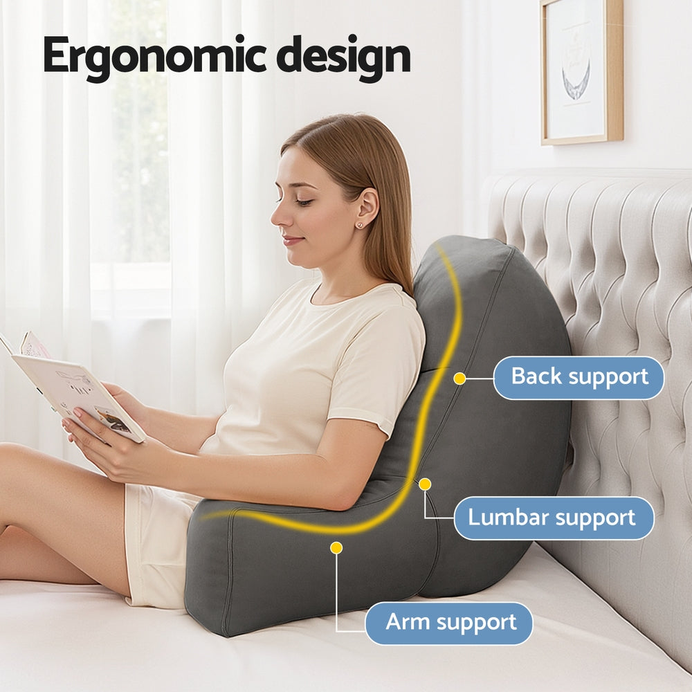 Grey reading backrest pillow with padded arm support while seated on a chair