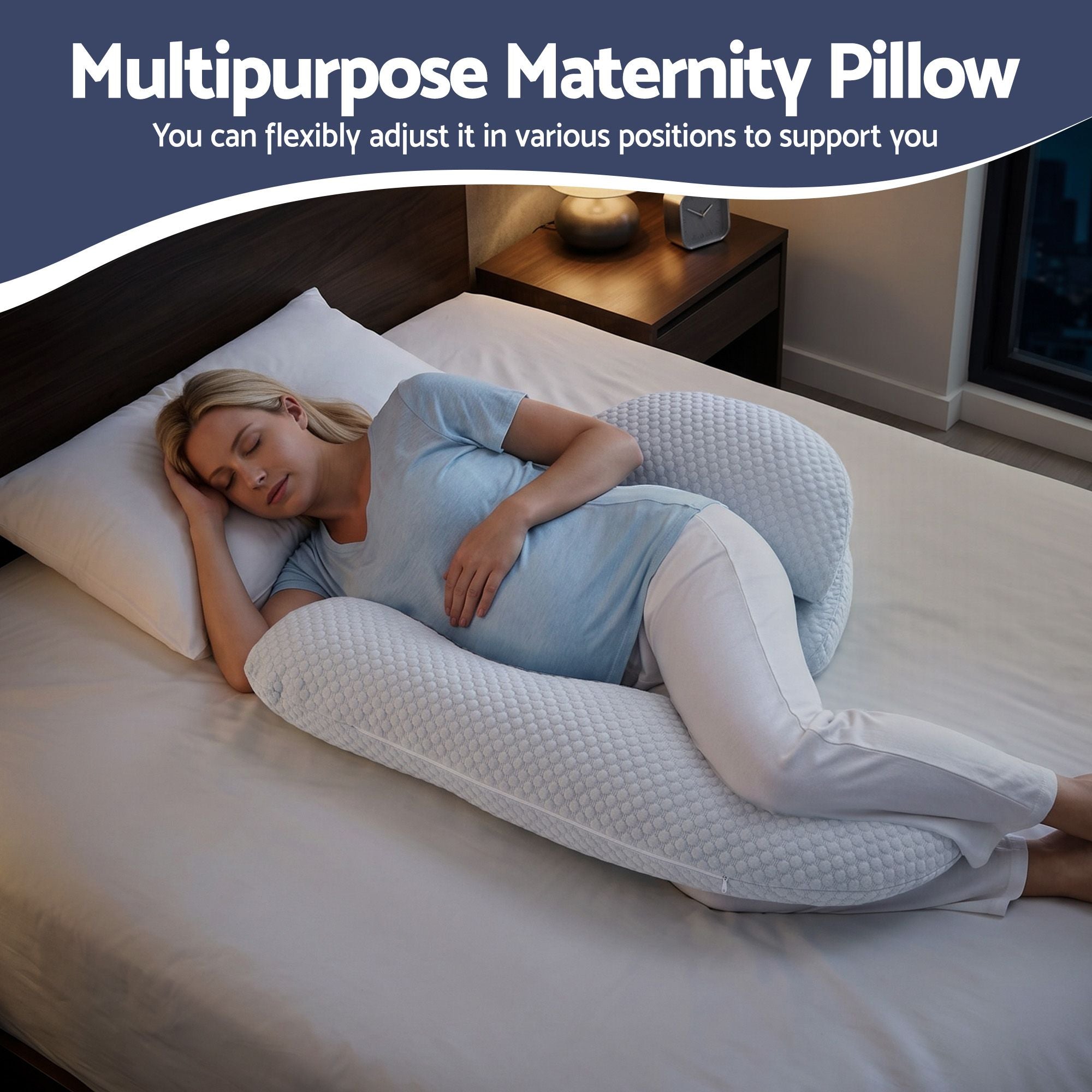 Light blue U-shaped maternity pillow on a bed for side sleeping support