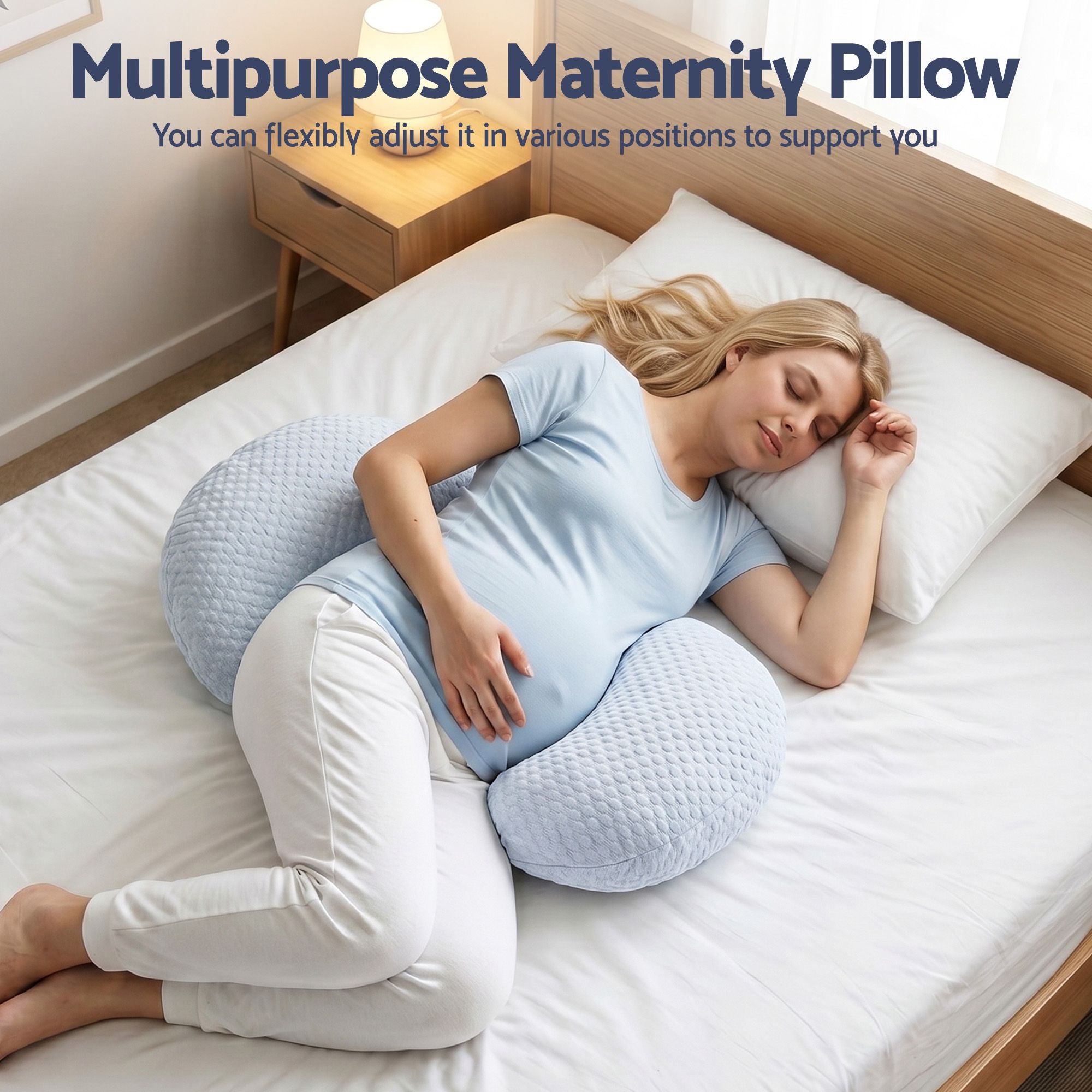 Light blue pregnancy pillow with curved body support contour, used for side lying