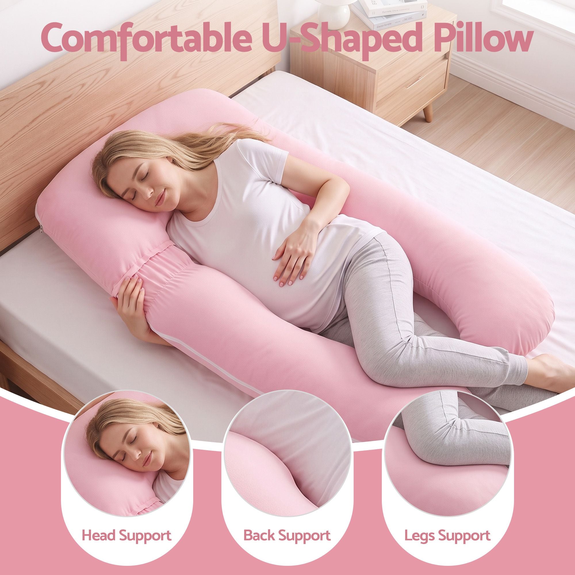 Pink U-shaped maternity pillow supporting head, back, and legs on a bed