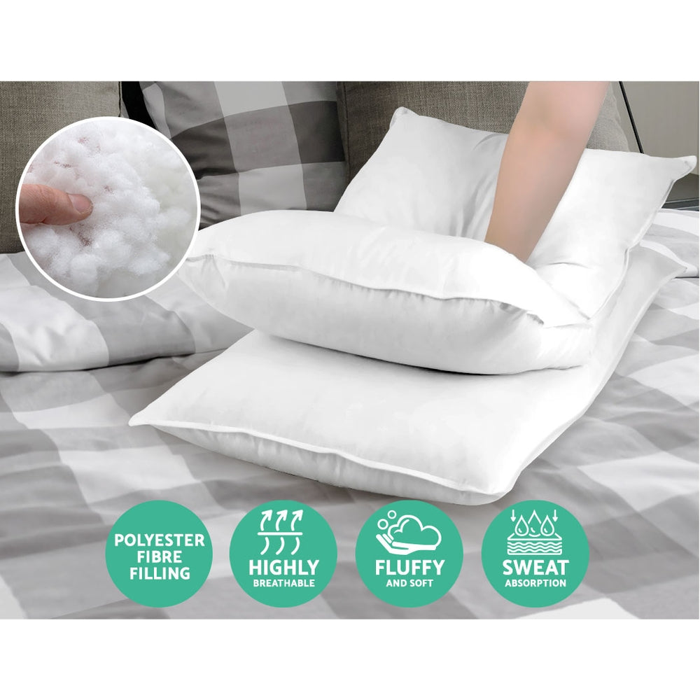 White bed pillow with fluffy filling, shown on a bed with a side view