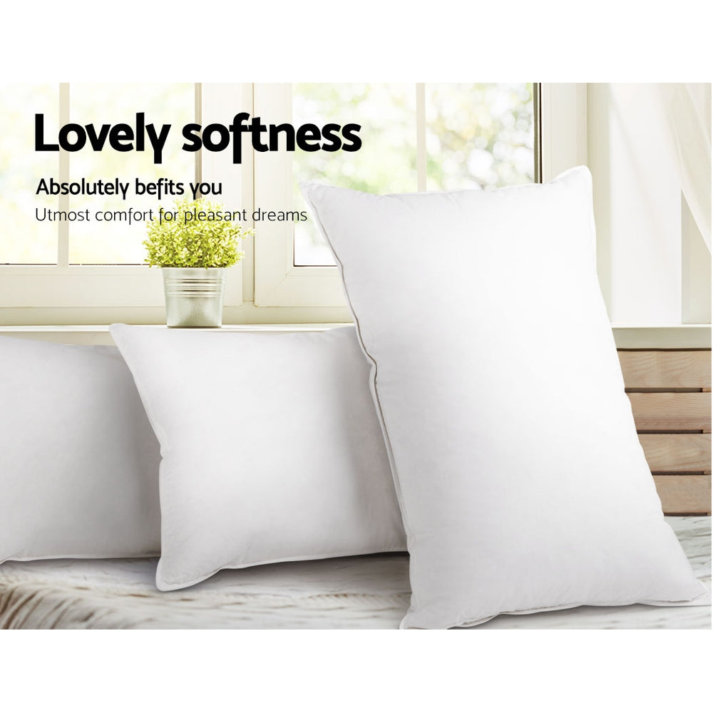 White bed pillow set with smooth cover, angled against a bed backrest