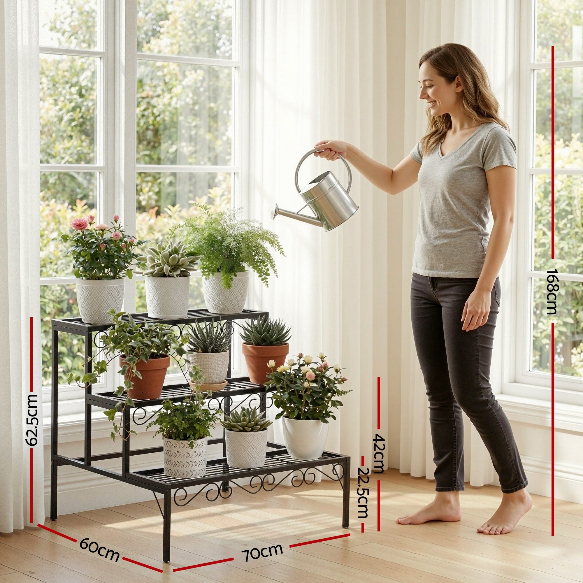 3-tier metal corner plant stand with scrollwork frame, holding potted plants by a window