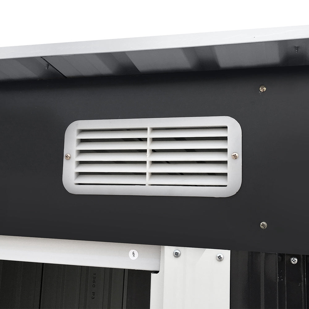 Vent louver detail on dark gray metal shed with white trim and mounting screws