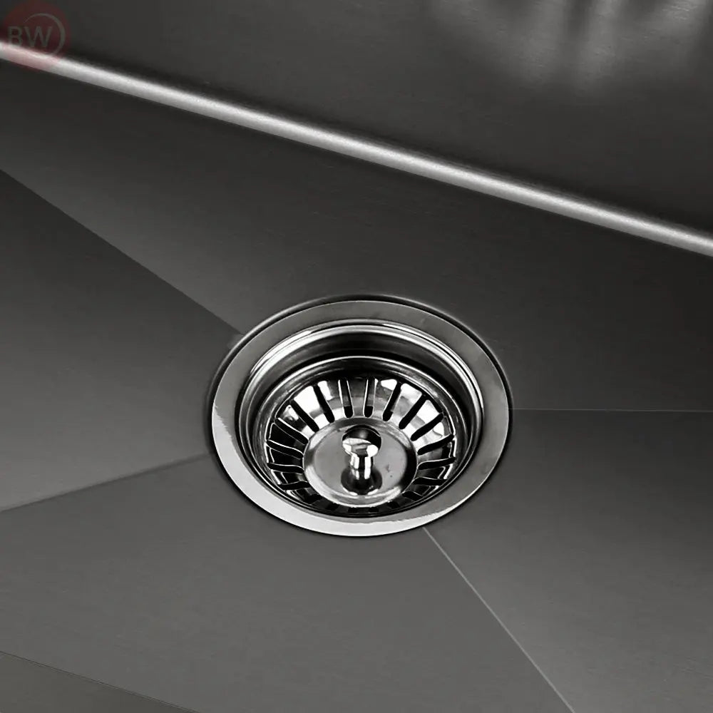 Round stainless drain strainer in a black kitchen sink basin