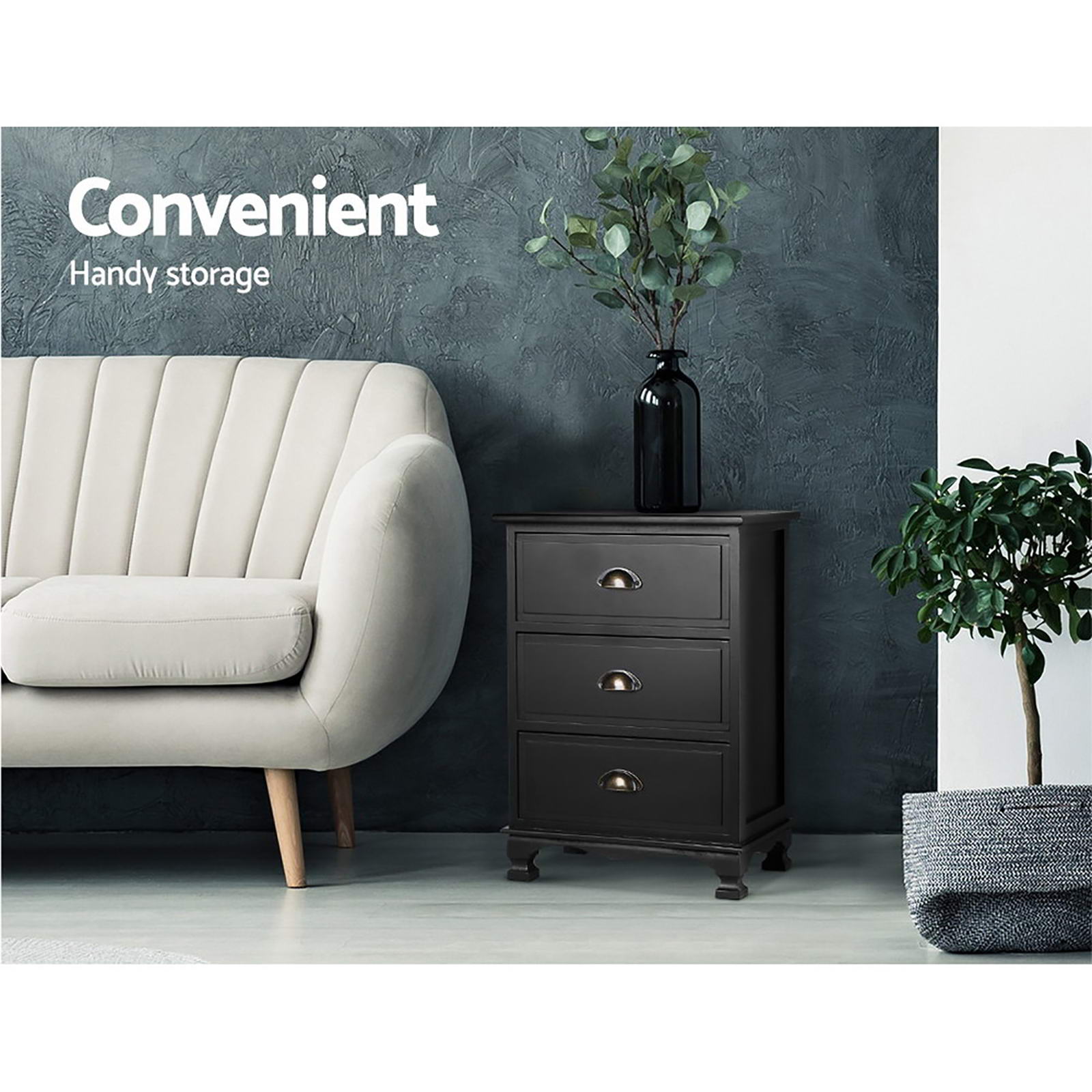 Black bedside table with three drawers and arched handles, styled beside a sofa