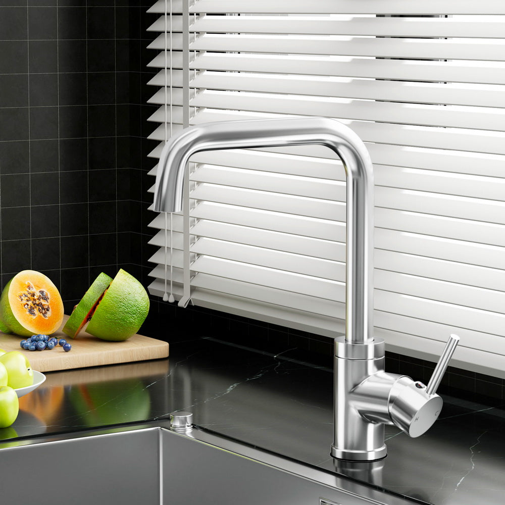 Chrome kitchen mixer tap with arched spout and side lever handle, mounted on sink.