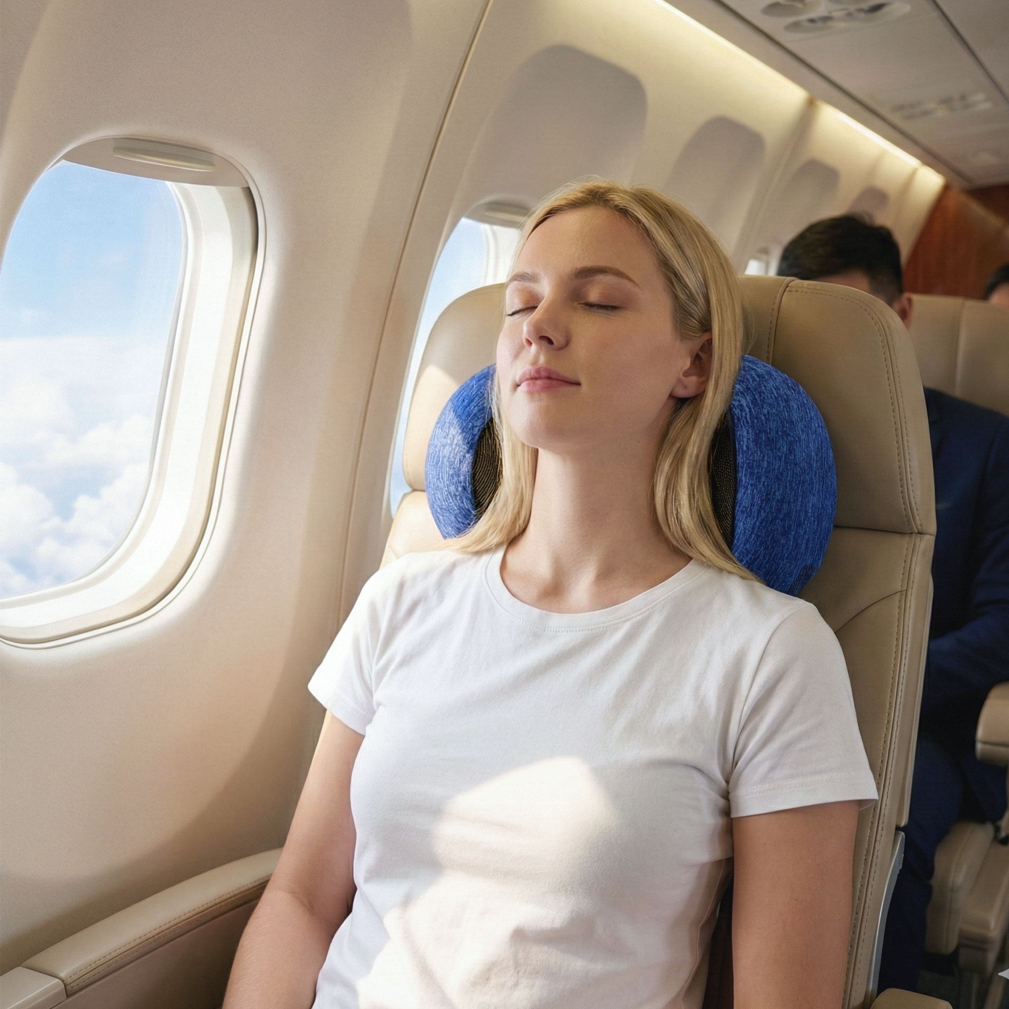 Blue ergonomic neck pillow around the neck on an airplane seat with black strap