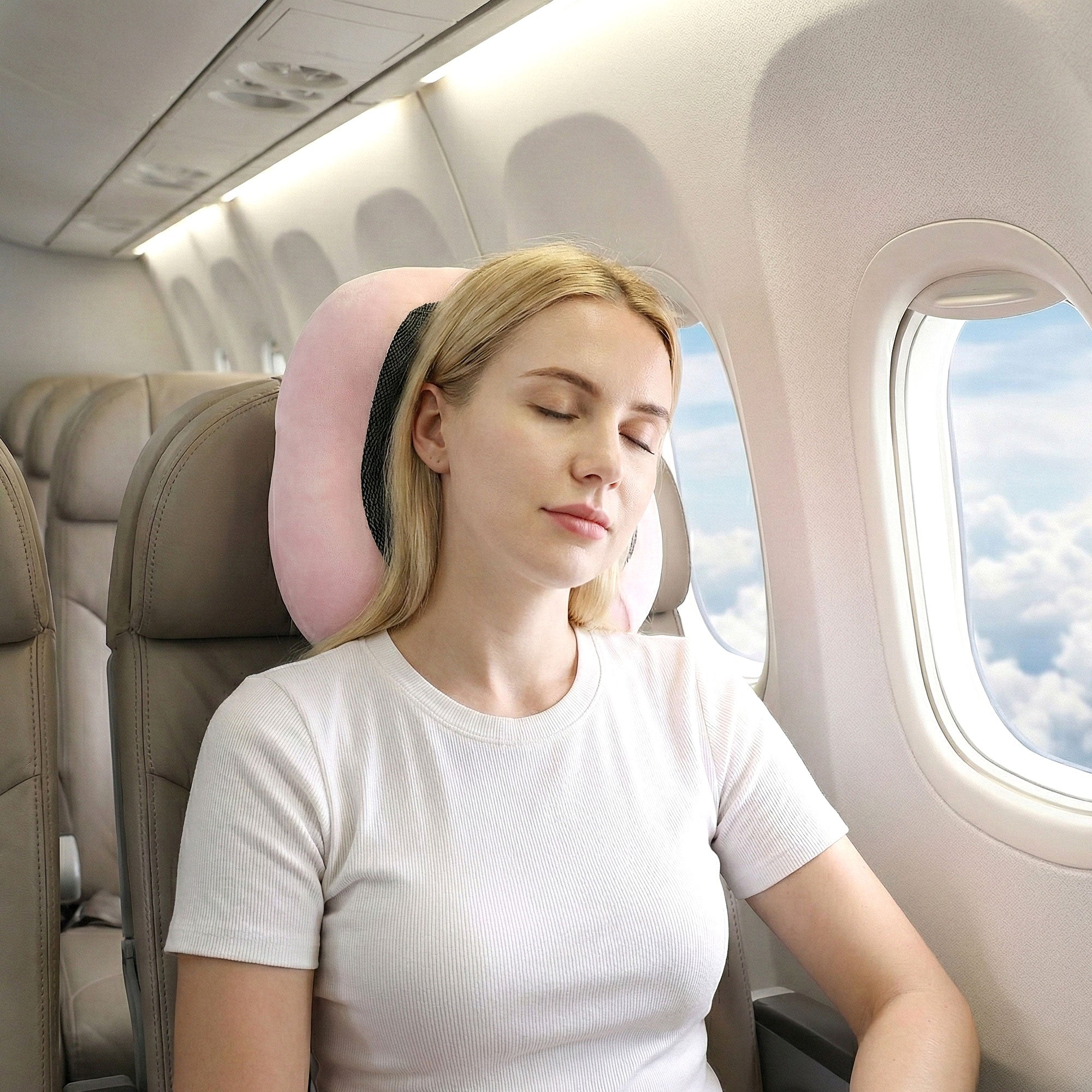 Pink travel neck pillow around neck with black breathable insert