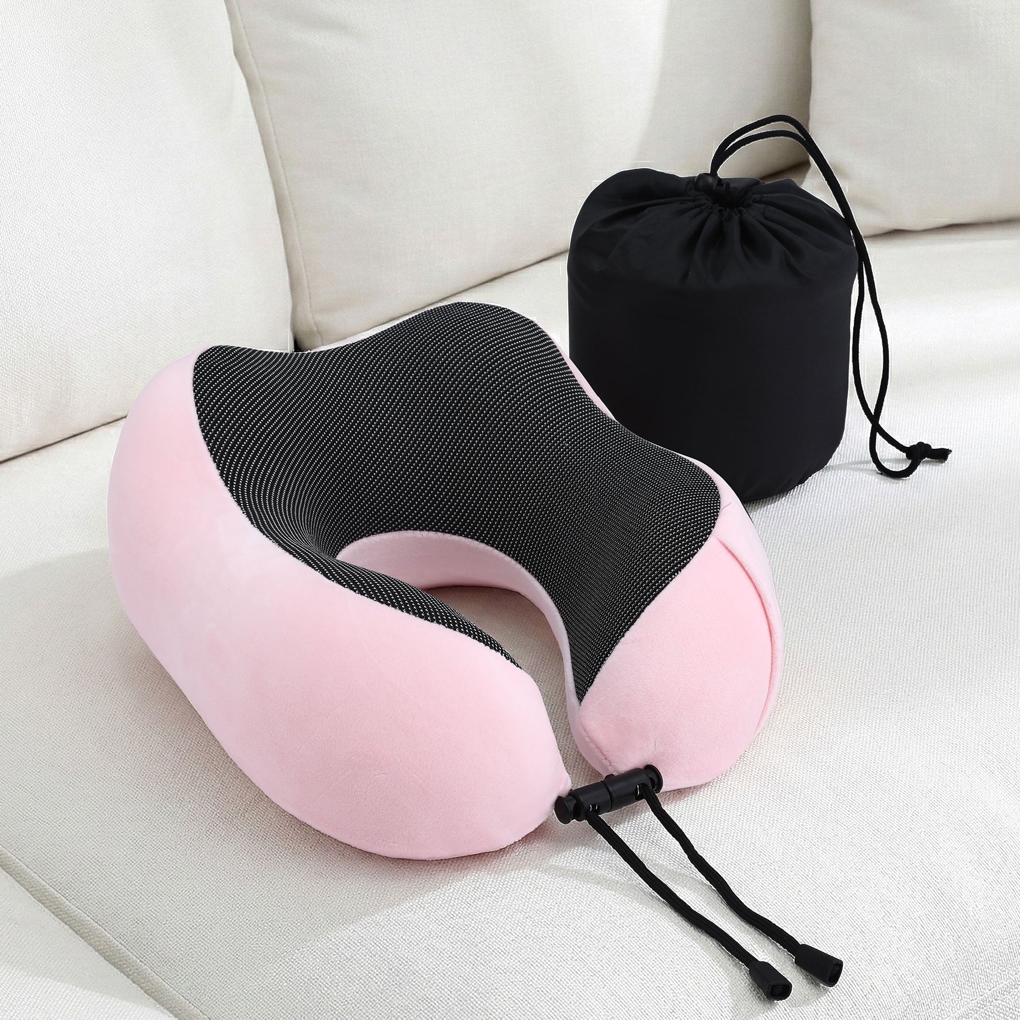 Pink and black travel neck pillow with drawstring storage bag and adjustable strap