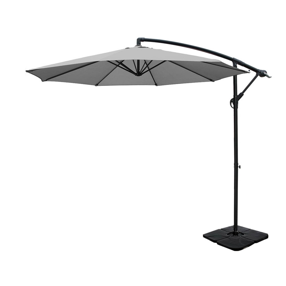 Grey cantilever patio umbrella with curved black support arm and square weighted base
