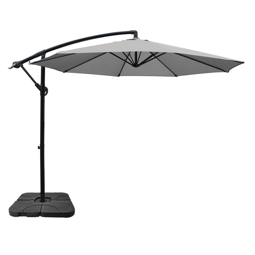 Grey cantilever outdoor umbrella on black pole with weighted base and open canopy