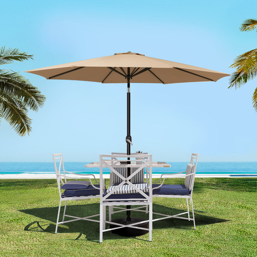 Beige outdoor umbrella over patio seating with black pole and round base