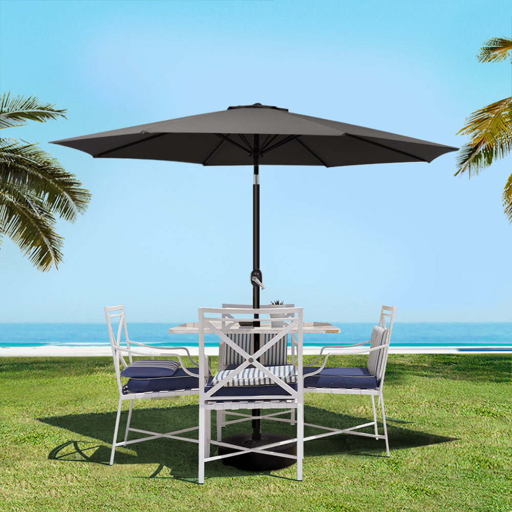 Black outdoor umbrella over patio dining set on grass