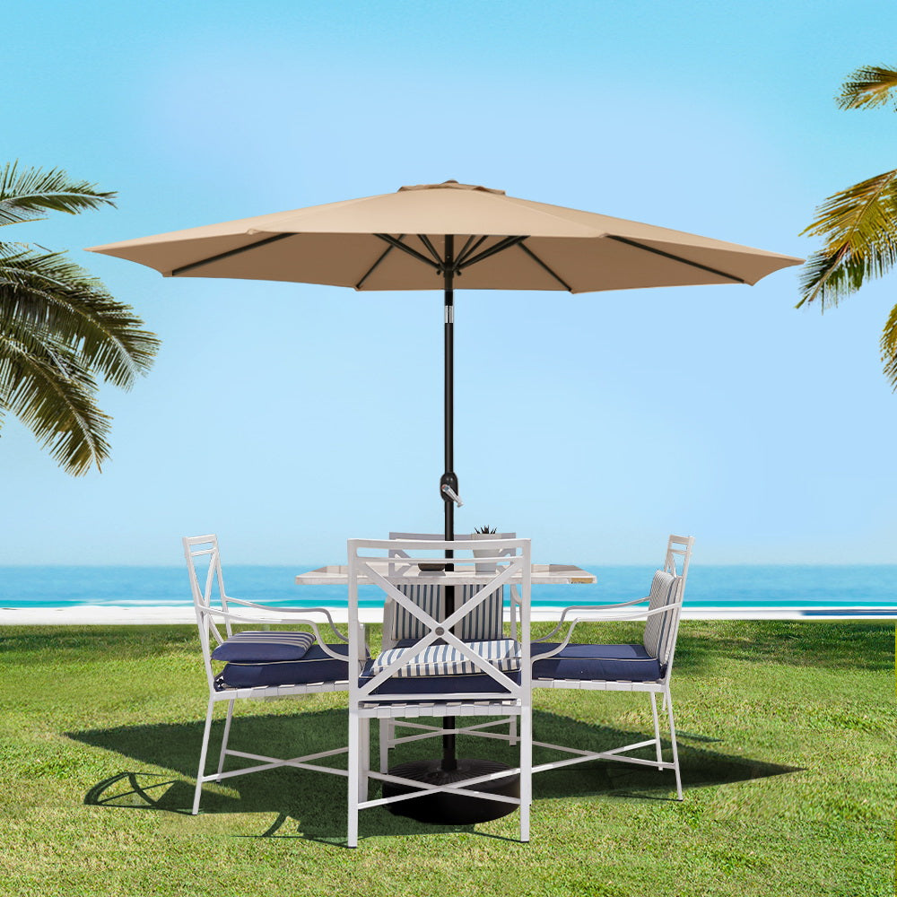 Outdoor umbrella with beige canopy and black pole over patio seating