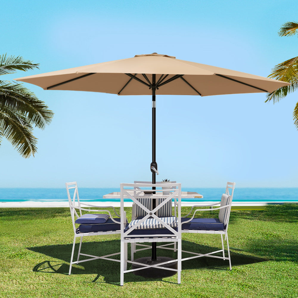 Beige outdoor patio umbrella open above black pole and base stand