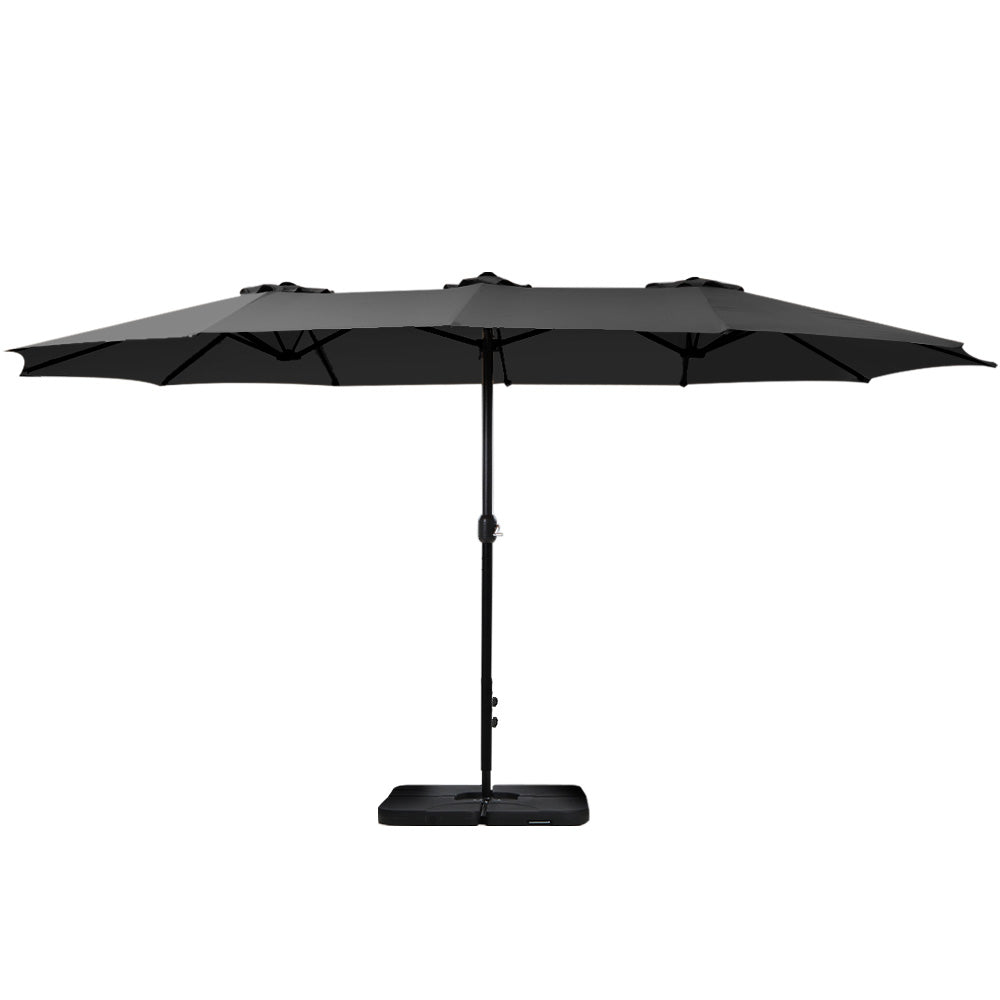 Black outdoor patio umbrella open with tilt pole and square weighted base.