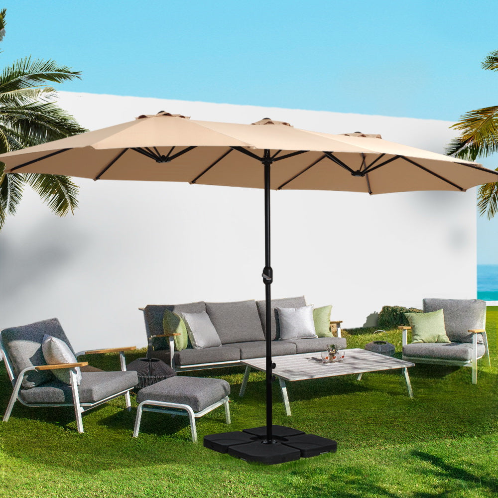 Beige outdoor umbrella over garden lounge set with black center pole