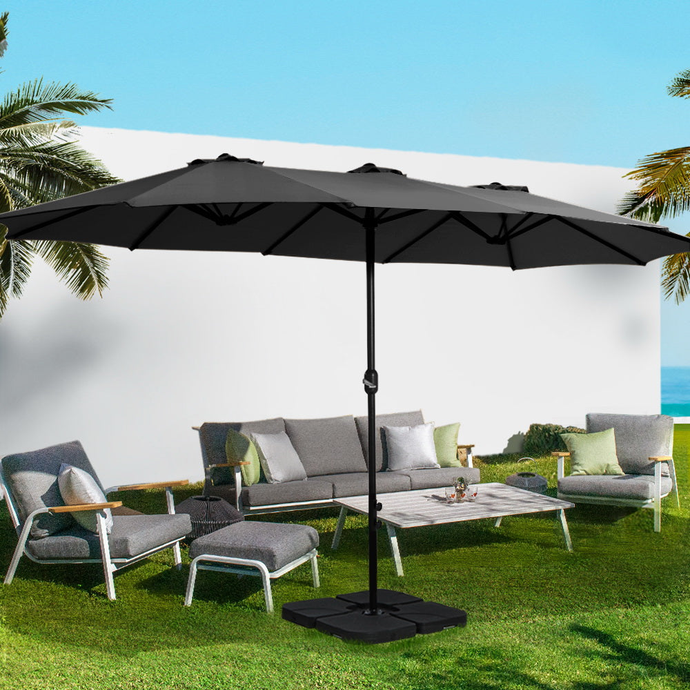 Black outdoor umbrella with open canopy and center pole, tilting crank mechanism.